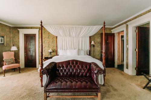 a bedroom with a bed and a leather couch at South Shire in Bennington
