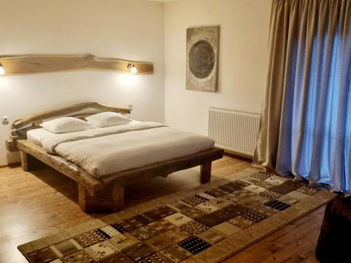1 dormitorio con cama y cortina azul en Mosorel, en Măgura