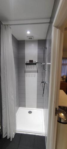 a bathroom with a shower with a shower curtain at ground floor studio in Deepcut