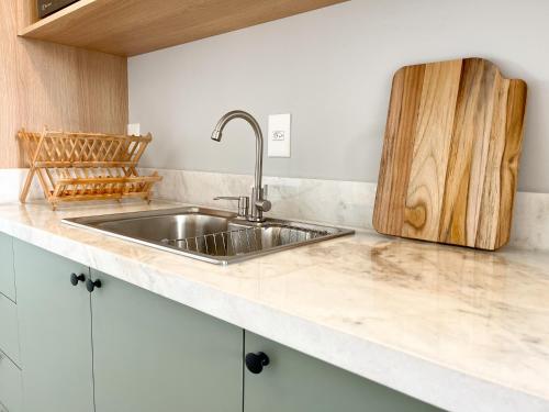 cocina con fregadero y tabla de cortar de madera en Bossa Mar Apartamento, en Bombinhas