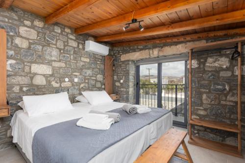 een slaapkamer met een groot bed in een stenen muur bij La Casa Di Pietre 1 in Kiotari