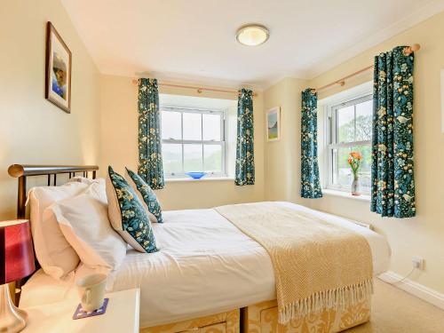 a bedroom with a bed and two windows at 2 Bed in Wasdale SZ515 in Nether Wasdale
