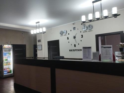 a reception counter with a clock on the wall at Ак-Тай Гостиный Двор in Ustʼ-Kamenogorsk