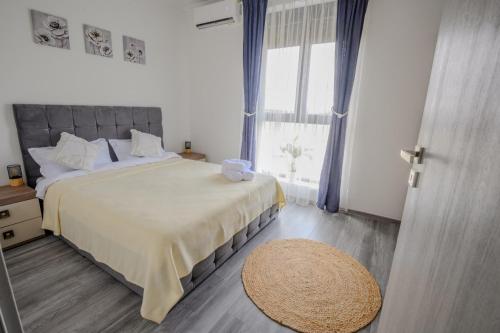 a bedroom with a large bed and a large window at Apartament Radiana in Baile Felix