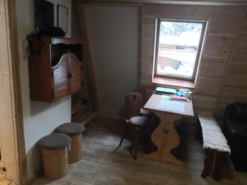 una piccola stanza con tavolo e sgabelli in una cabina di Chata Zuzka pod Babou horou a Oravská Polhora