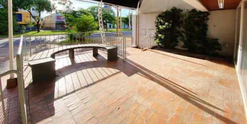 une ombre d'un banc sur un trottoir en briques dans l'établissement Itaipu Hotel, à Foz do Iguaçu