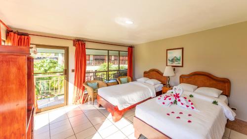a bedroom with two beds and a balcony at Hotel Lavas Tacotal in Fortuna