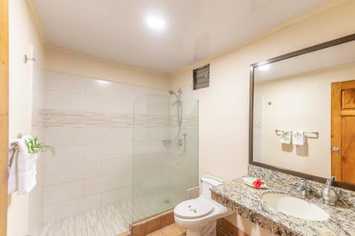 a bathroom with a shower and a toilet and a sink at Hotel Lavas Tacotal in Fortuna
