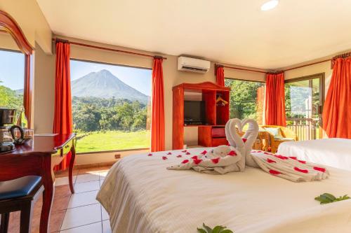 a bedroom with a bed with a view of a mountain at Hotel Lavas Tacotal in Fortuna