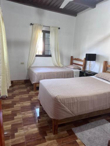 een slaapkamer met 2 bedden en een raam bij Hotel Princess Inn in Agua Azul
