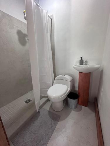 Baño blanco con aseo y lavamanos en Hotel Princess Inn, en Agua Azul