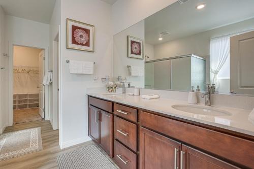 La salle de bains est pourvue d'un lavabo et d'un grand miroir. dans l'établissement Las Vegas Vacation Rental Private Patio and Yard, à Las Vegas