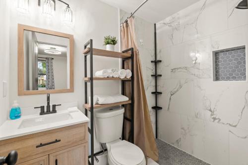 y baño con aseo, lavabo y ducha. en New Decatur Bungalow en Decatur