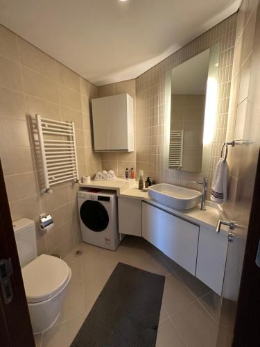 a bathroom with a toilet a sink and a mirror at stylish flat-eagle eye for istanbul in Istanbul