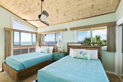 2 camas num quarto com janelas em Renovated 2br Condo with Ocean Views - Alekona Kauai em Koloa