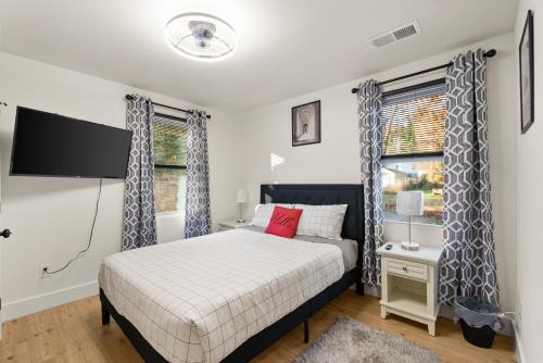 a bedroom with a bed and a tv and windows at New Decatur Bungalow in Decatur