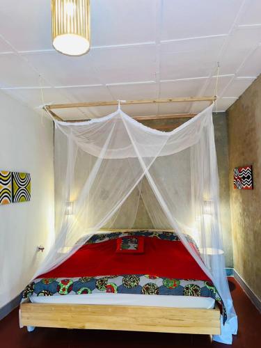 a bedroom with a bed with a mosquito net at Isange Paradise Resort in Ruhengeri