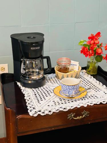 a coffee maker and a cup on a table at Casa Tres Colibries in Mérida