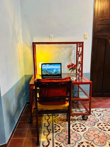 a desk with a laptop computer on top of it at Casa Tres Colibries in Mérida