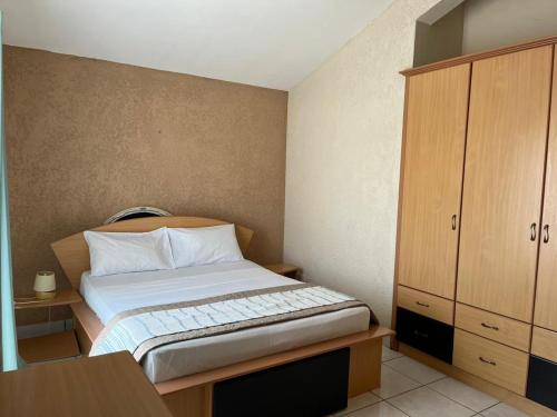 a small bedroom with a bed and a cabinet at Le Dattier - Three bedroom apartment - Coquillage in Flic-en-Flac