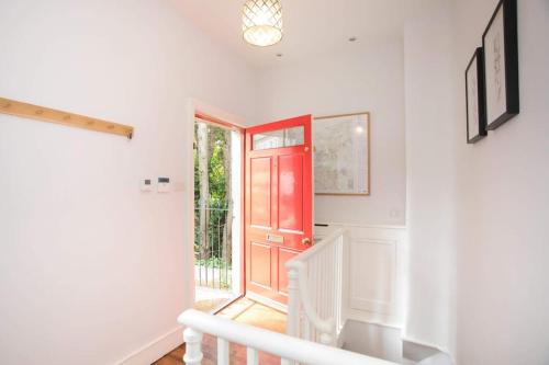 un pasillo con una puerta roja y una escalera en Historic House On The Bridge en Bath