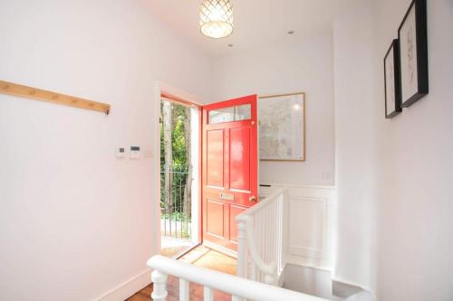 a hallway with a red door and a staircase at Historic House On The Bridge in Bath