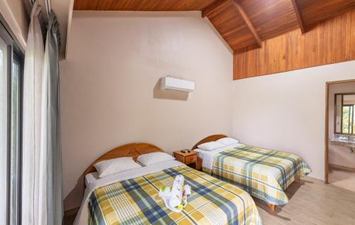 two beds sitting next to each other in a room at Hotel Lavas Tacotal in Fortuna