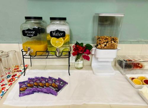 a table with two jars of water and orange juice at Casa Tres Colibries in Mérida