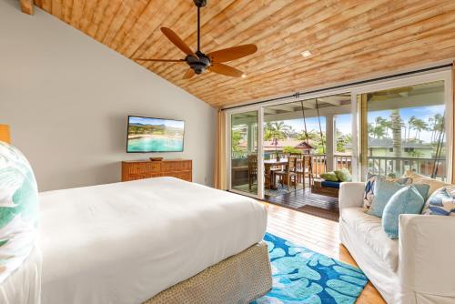 - une chambre avec un grand lit et un canapé dans l'établissement Cute 4br home steps to the Ocean - Alekona Kauai, à Koloa