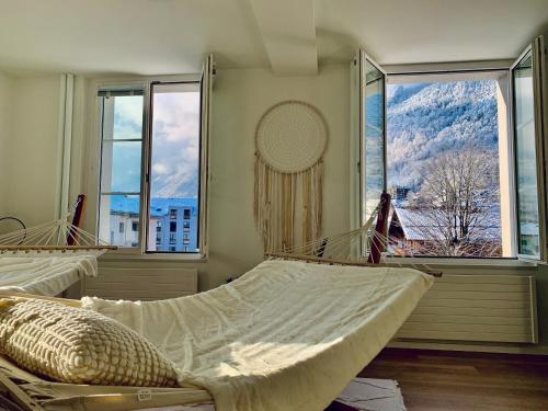 two beds in a room with large windows at EVA o Wellnessoasis o Montainview o Pizzaoven o in Ingenbohl