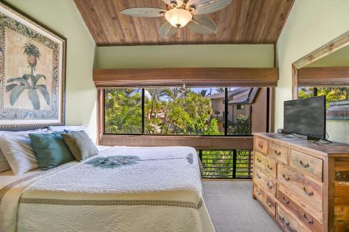 a bedroom with a bed and a dresser with a television at Unique Oceanfront Condo with AC- Alekona Kauai in Koloa