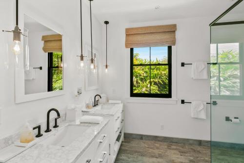 a white bathroom with two sinks and a shower at 4BR Poipu Home with Private Pool- Alekona Kauai in Koloa