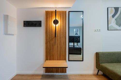 a living room with a mirror and a couch at Nena Apartments Berlin Adlershof in Berlin