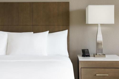 a bedroom with a bed and a lamp on a nightstand at DoubleTree by Hilton Orlando Airport Hotel in Orlando