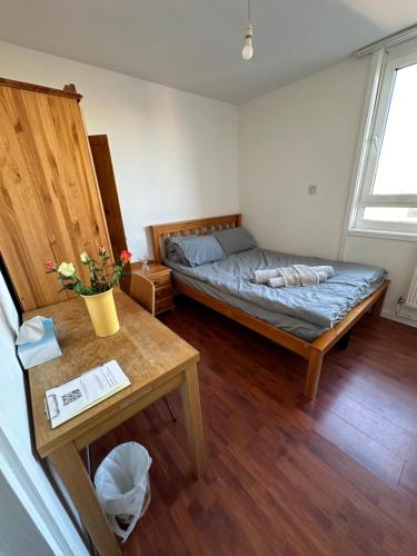 Zimmer mit einem Bett und einem Tisch in der Unterkunft Elkington Point in London
