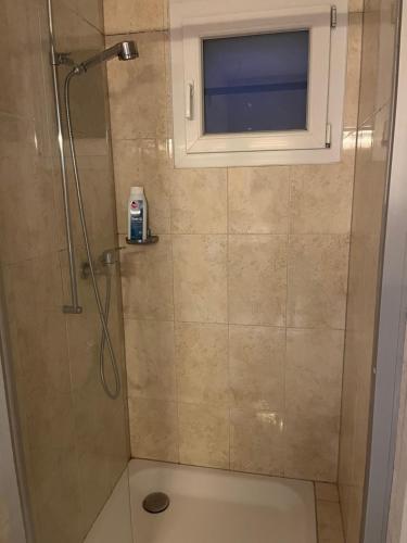 uma casa de banho com um chuveiro e uma janela em Grande chambre avec Salle de Bains Privative em Lausanne