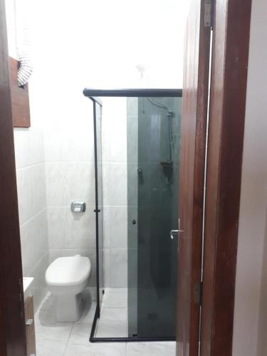 uma casa de banho com uma cabina de duche em vidro e um WC. em A caminho do farol em Laguna