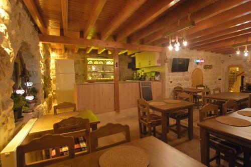 a restaurant with wooden tables and chairs and a kitchen at Euphoria Cave House in Nar