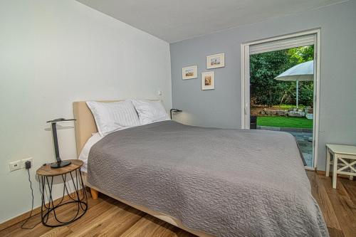 a bedroom with a large bed and a window at Athens Voula garden bungalow in Athens