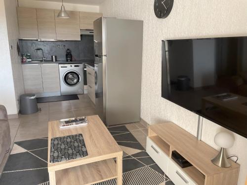 een woonkamer met een televisie en een keuken bij T2 Saint-Mandrier-sur-Mer in Saint-Mandrier-sur-Mer