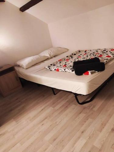 Bett in einem Zimmer mit Holzboden in der Unterkunft studio 6 in Chalon-sur-Saône