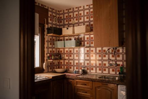 a kitchen with a sink and a tile wall at Casa rural Hitohouse Bed&Climb in Albarracín