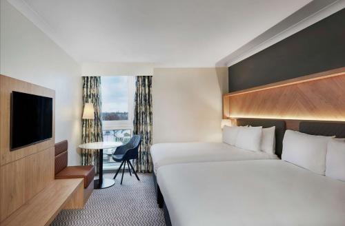 a hotel room with a bed and a television at Hilton London Croydon in Croydon