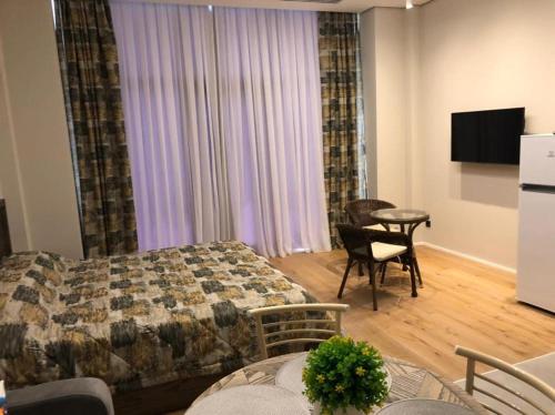 a bedroom with a bed and a table and chairs at SEA BREEZE LIGHTHOUSE in Baku