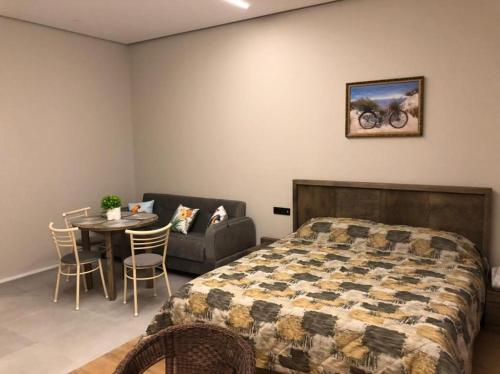 a bedroom with a bed and a table and a couch at SEA BREEZE LIGHTHOUSE in Baku