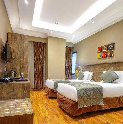 a hotel room with two beds and a television at Al Ansar Golden Tulip in Medina