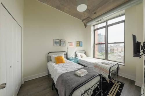 two beds in a room with a window at McCormick 2Br/2Ba family unit for up to 6 guests with Optional Parking & Gym in Chicago