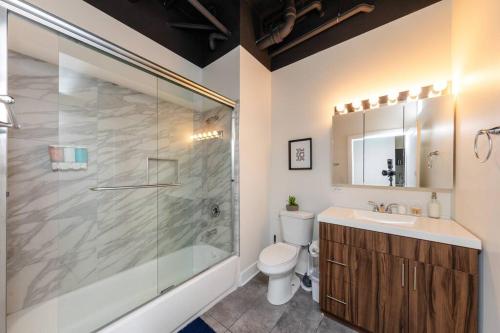 a bathroom with a shower and a toilet and a sink at McCormick 2Br/2Ba family unit for up to 6 guests with Optional Parking & Gym in Chicago