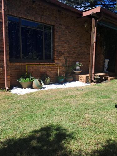 a brick house with potted plants in a yard at La Château B&B in Springs