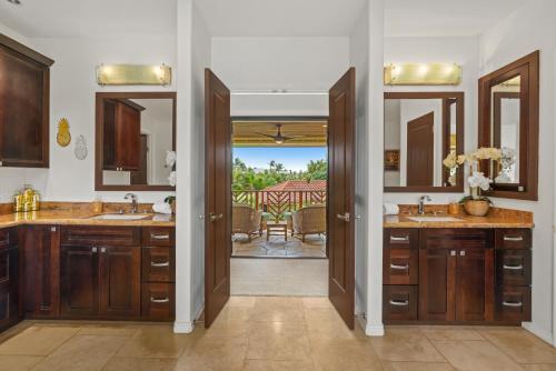 a bathroom with two sinks and two mirrors at Custom 4br Home Walking Distance to Beach - Alekona Kauai in Koloa